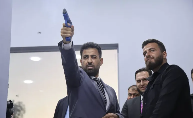 مسدس في يد وزير الصحة السوري يثير الجدل في معرض دمشق